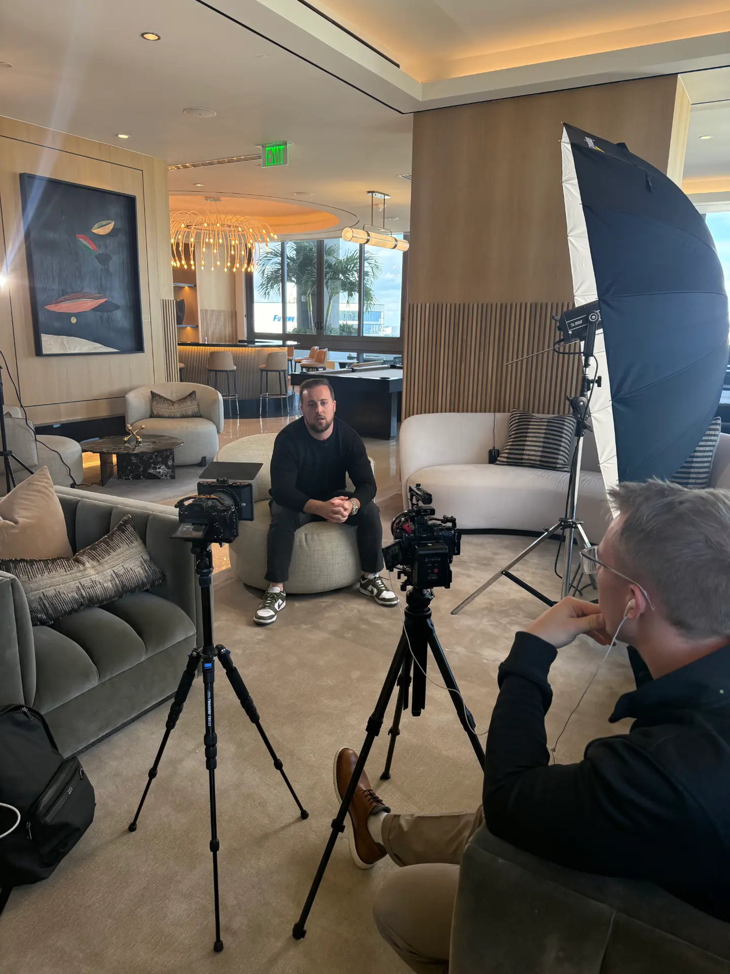 Interview recording session in a modern lounge with cameras and lighting set up